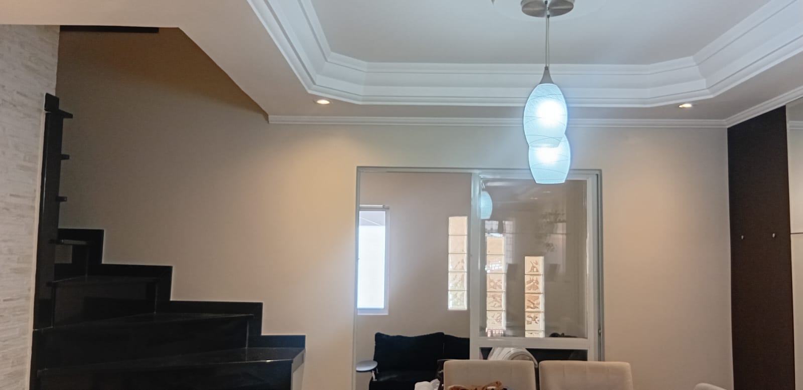 Sanca de gesso com molduras decorativas clássicas e lustre em sala de estar.